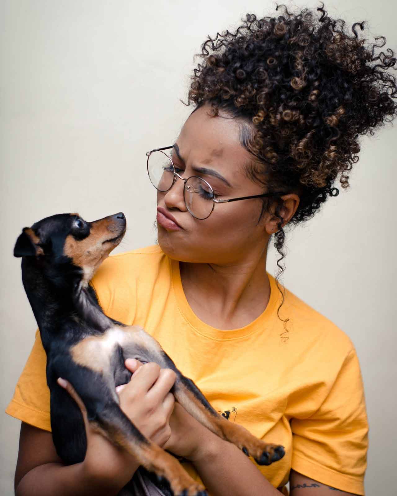 woman-holding-short-coated-black-and-brown-puppy-3190736